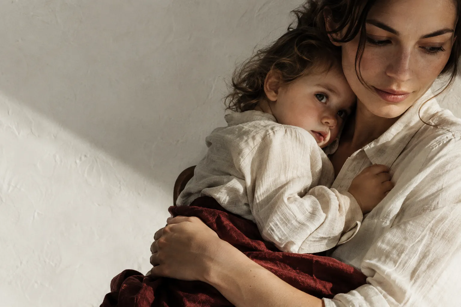 A mother holding her young child close at home